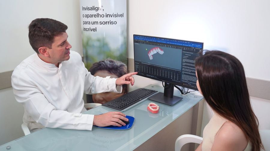 Dr. Rodrigo Sandin em atendimento no consultório, apresentando plano de tratamento Invisalign a paciente